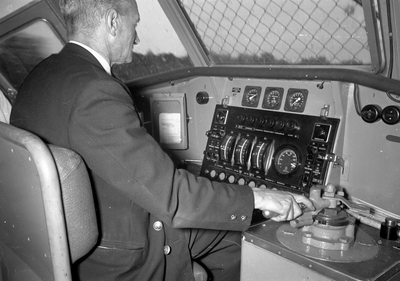 839985 Afbeelding van machinist W.C.J. van Geloven in de stuurstand van het electrische treinstel nr. 757 (mat. 1954, ...